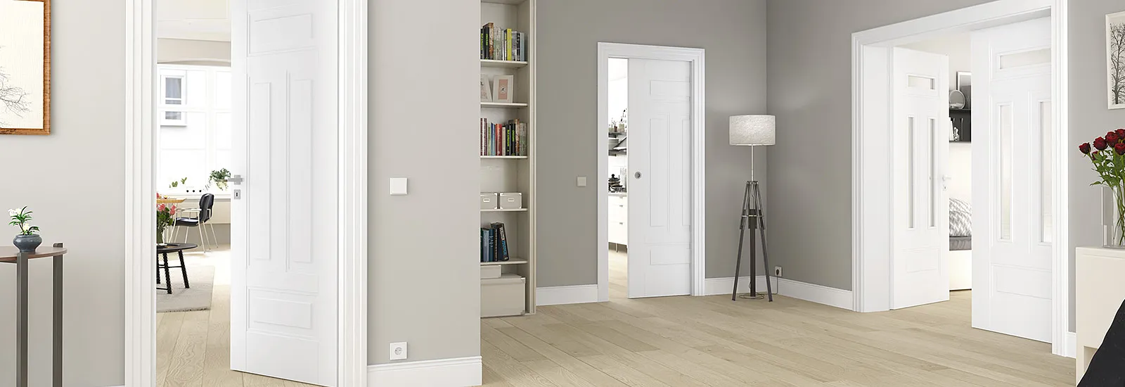 Heller Innenraum mit hellem Holzfußboden, grauen Wänden und mehreren geöffneten weißen Innentüren in Weißlackoptik; sichtbare weiße Türrahmen und Sockelleisten, offenes Bücherregal, dreibeinige Stehleuchte, kleiner Beistelltisch mit Pflanze und Vase sowie Blick in angrenzende Räume mit Stuhl und Tisch.