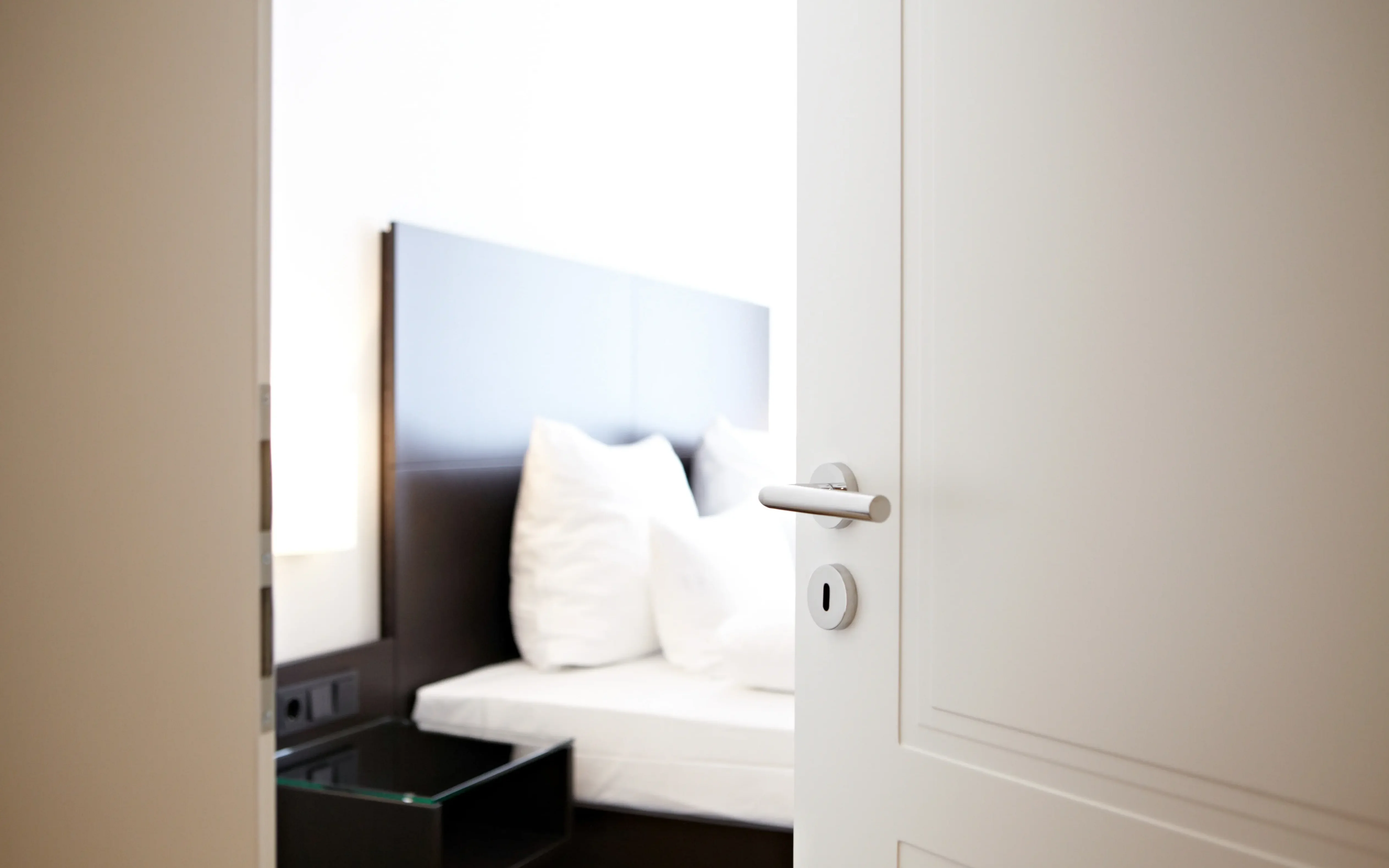 Offenstehende weiße Tür die ins Schlafzimmer führt 